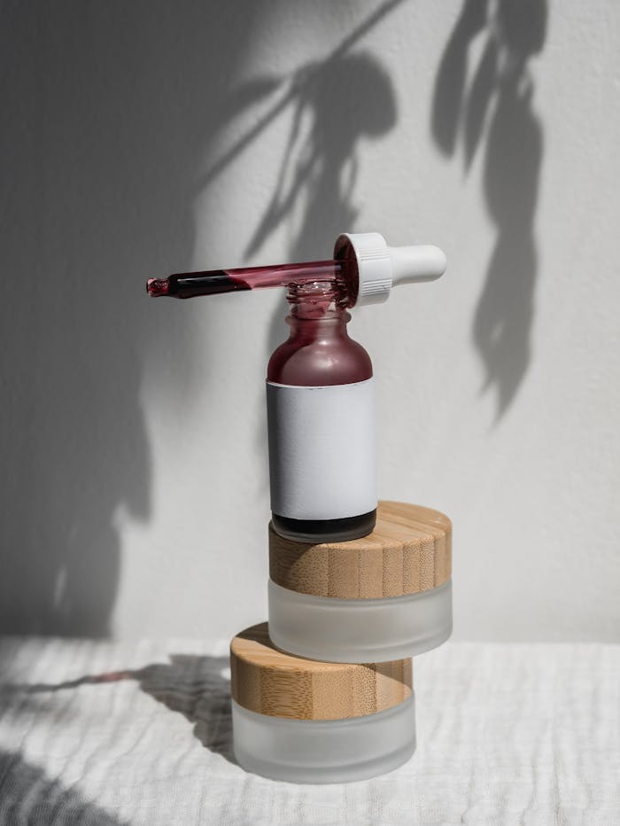 hero-img-02 Still life of a minimalist cosmetic dropper bottle with shadow play, perfect for product mockups.